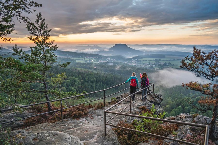 Zwei Wanderinnen genießen den Sonnenuntergang auf dem Papstein. Foto: TVSSW/Philipp Zieger